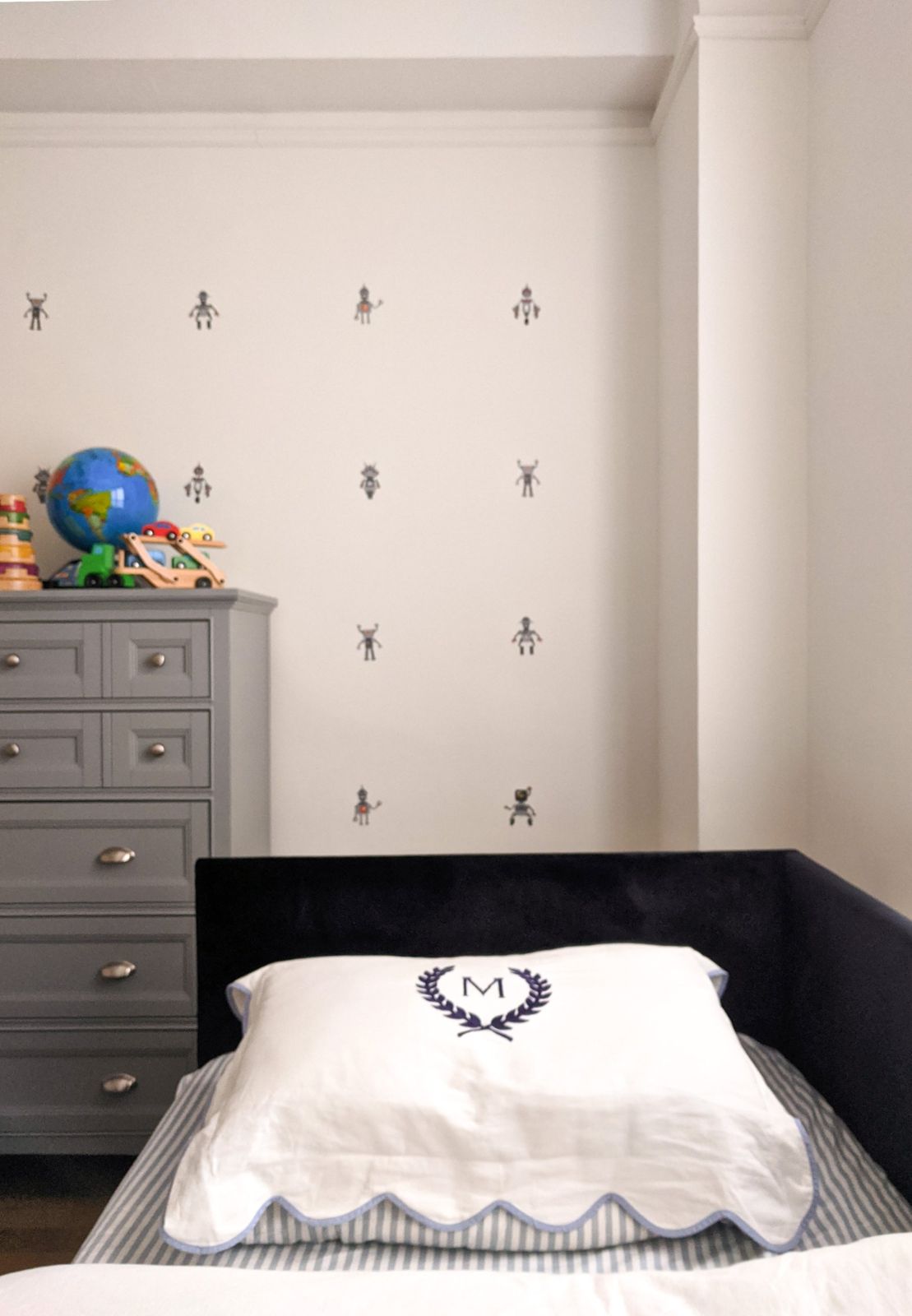 Child bedroom with robot wallpaper and monogrammed pillow