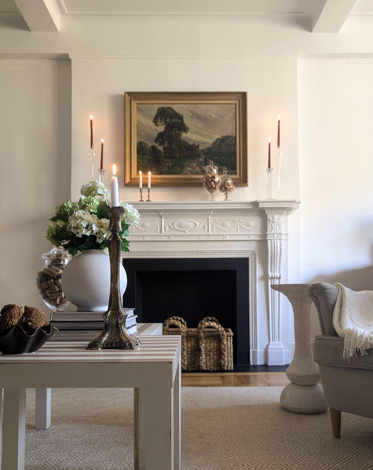 Living room with carved mantel and gilt-framed landscape