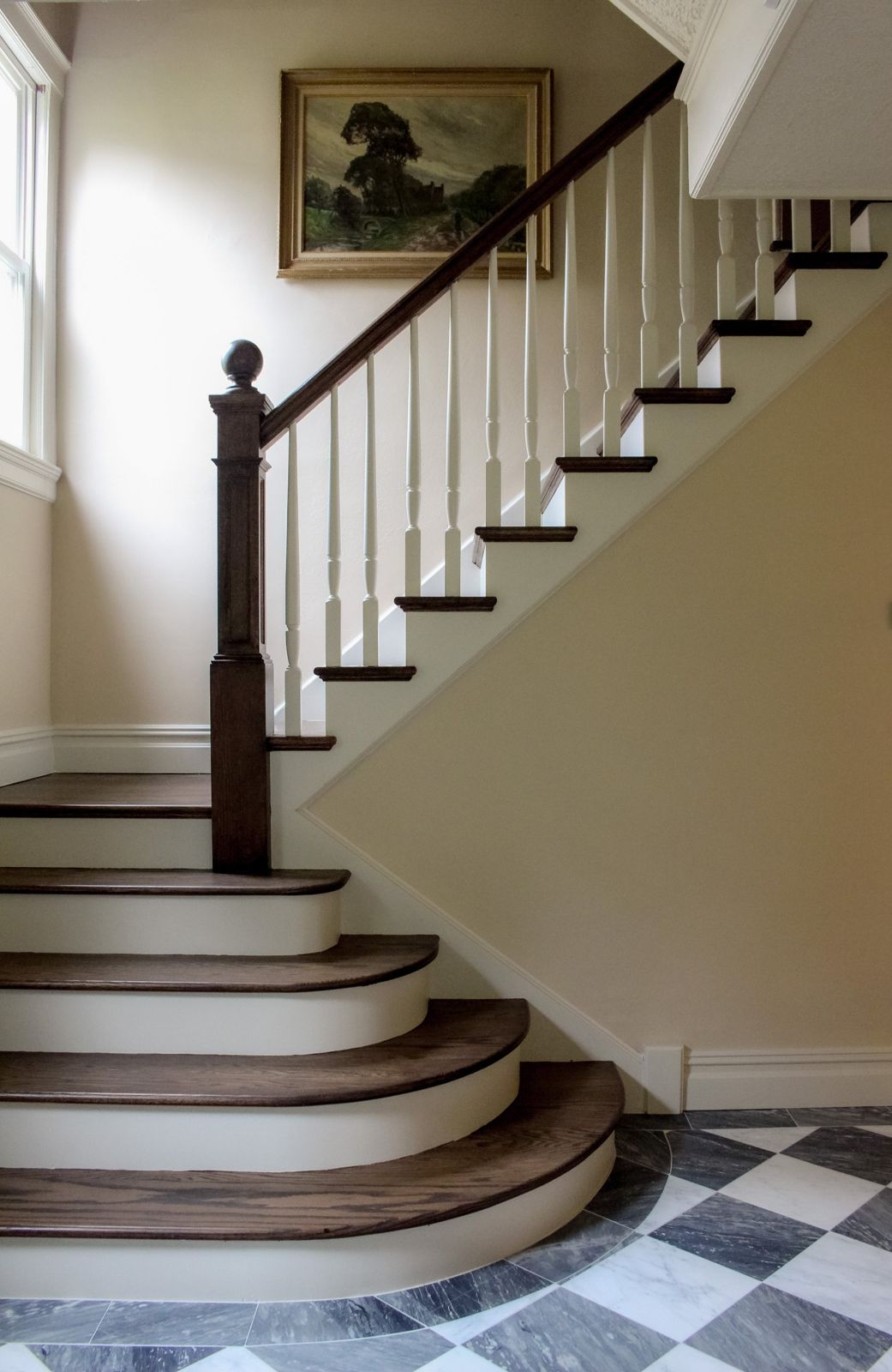 Oak staircase with curved steps and marble floor